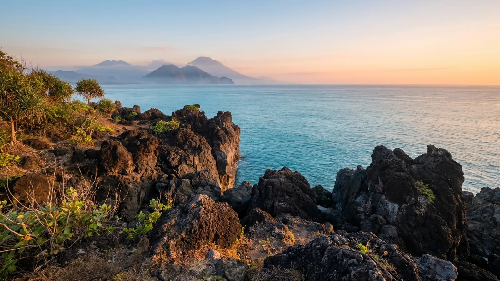 Sunrise over volcanic landscape with calm ocean in the distance