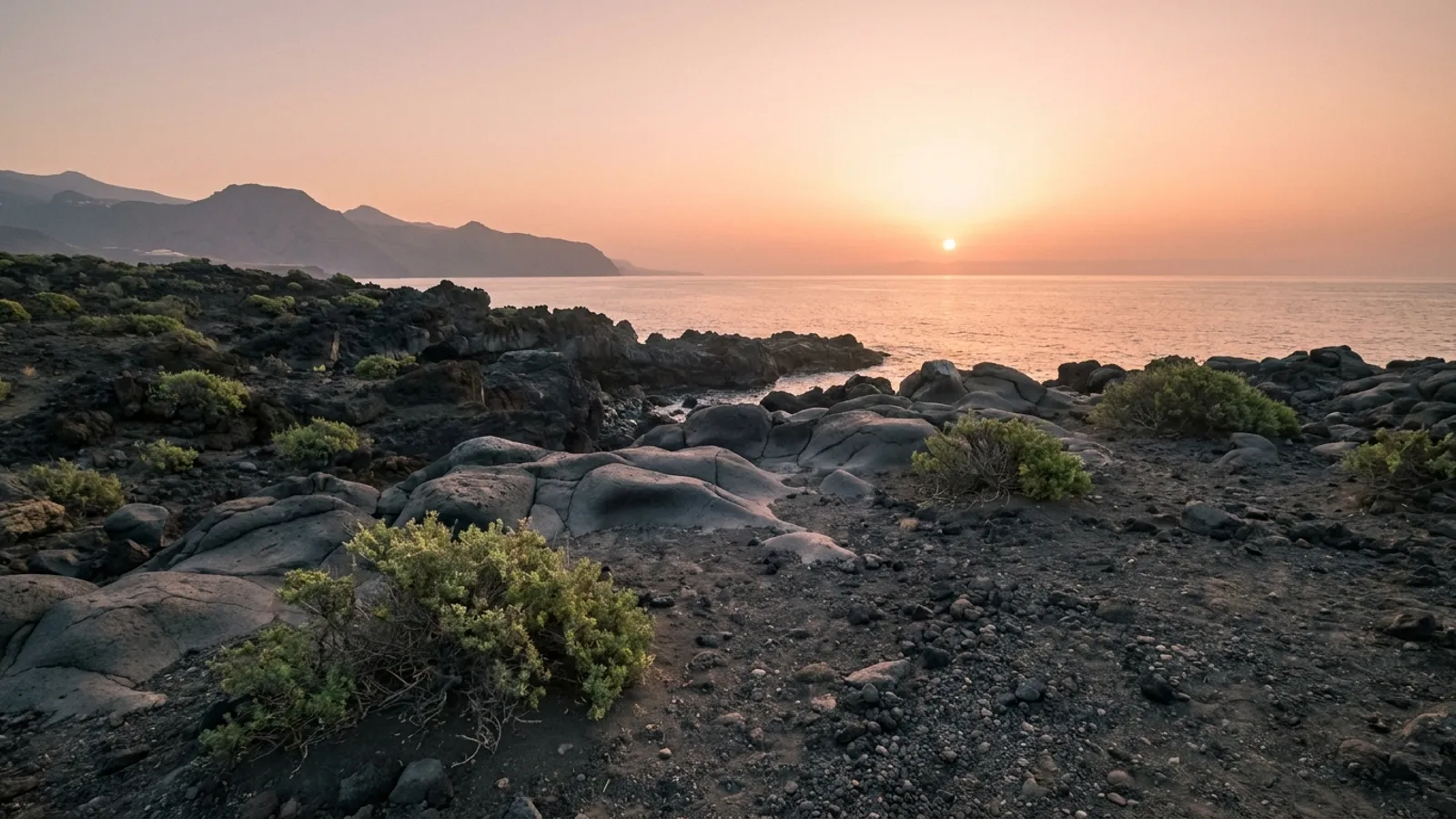 Sunrise over volcanic landscape with calm ocean in the distance, Tenerife